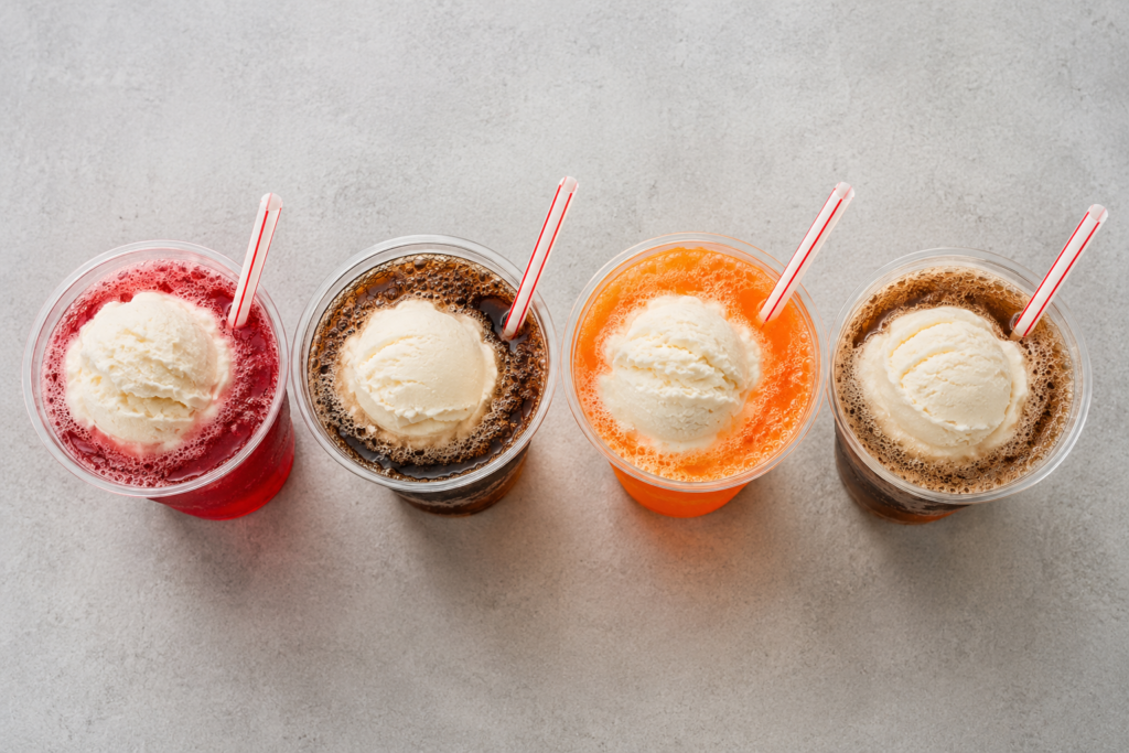 Four Cook Out soda floats side by side, Cheerwine, Coke, Fanta, and Root Beer floats with vanilla soft serve